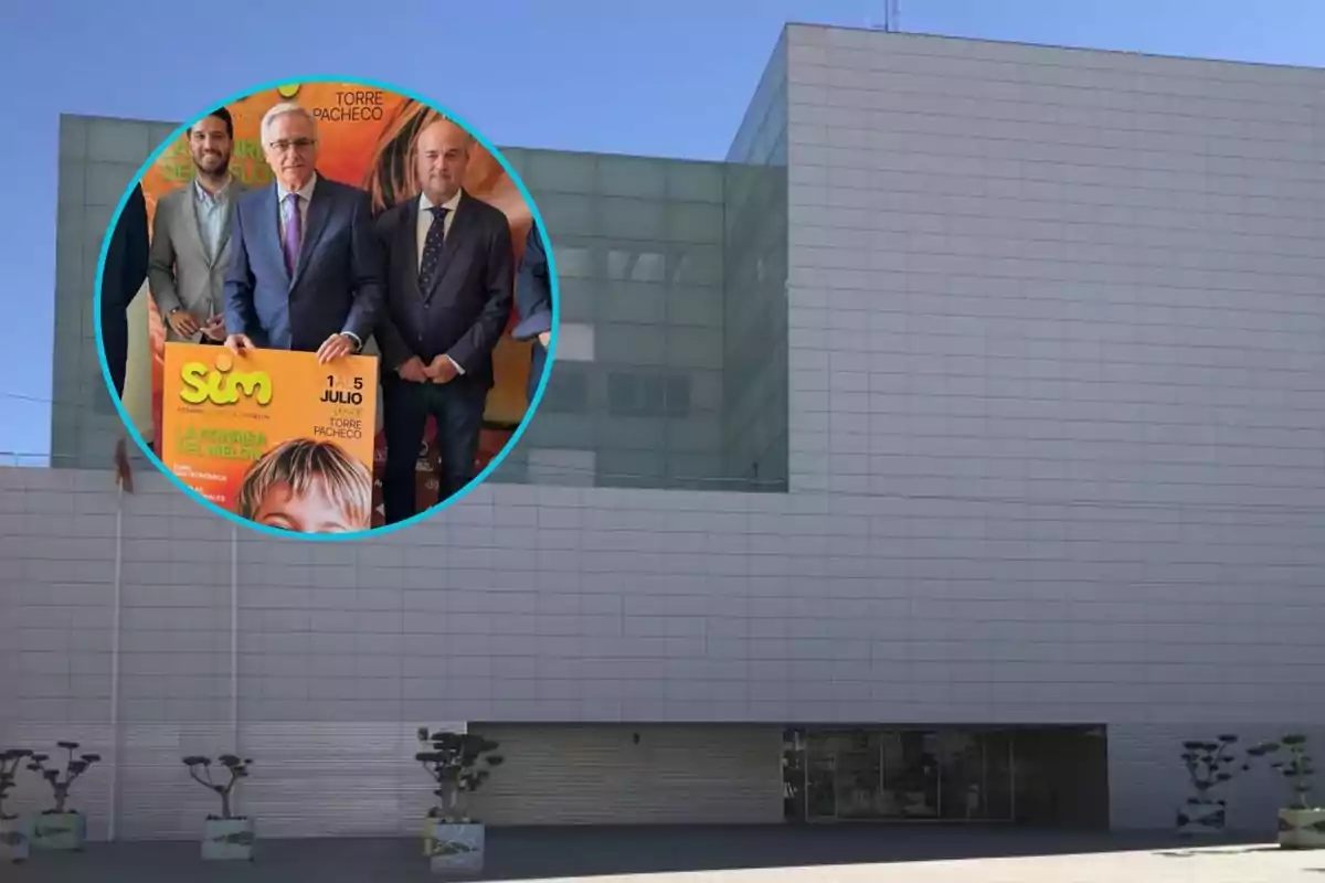 Fachada de un edificio moderno de color claro con un círculo superpuesto que muestra a tres hombres en traje sosteniendo un cartel promocional de un evento llamado Sim