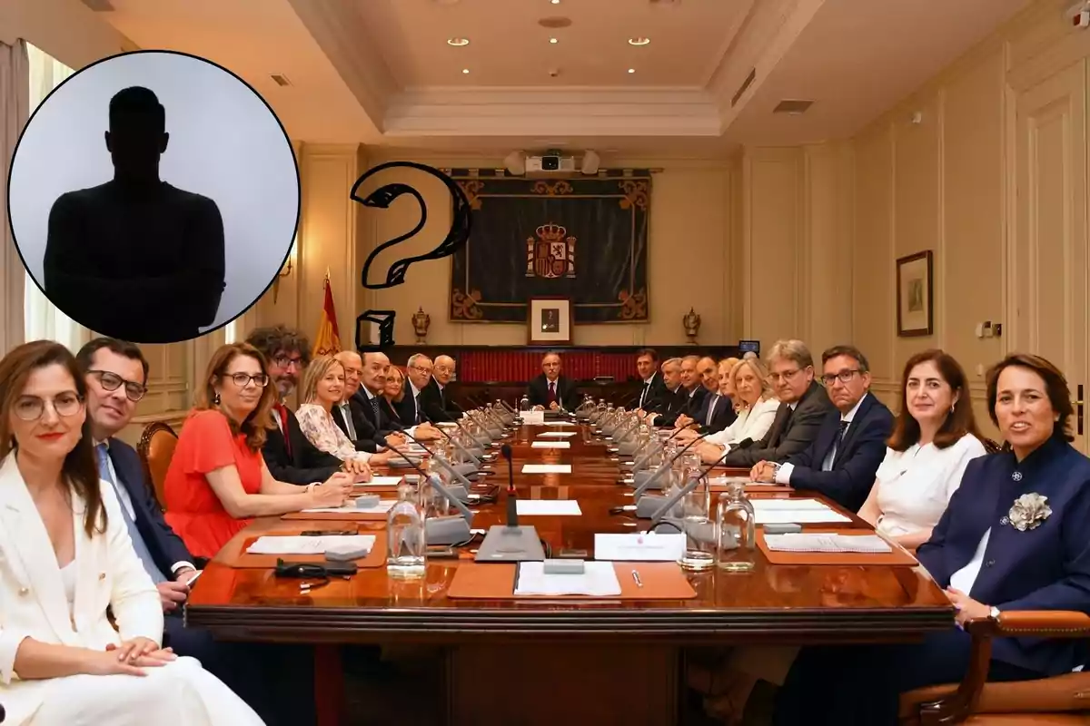 Un grupo de personas sentadas alrededor de una mesa de conferencias en una sala de reuniones formal, con una bandera de España y un escudo en la pared del fondo, y una silueta de una persona con un signo de interrogación en la esquina superior izquierda.