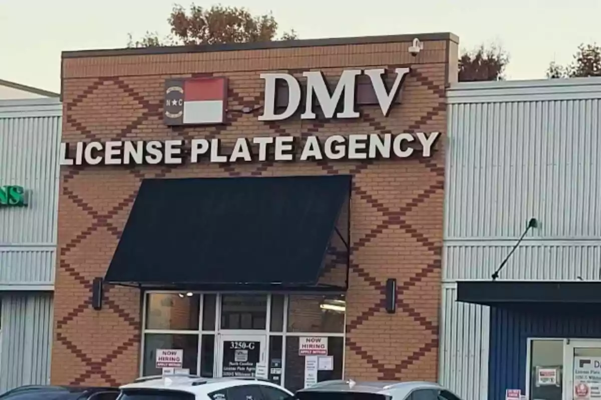 Facade of a DMV License Plate Agency office with a black awning and several cars parked in front