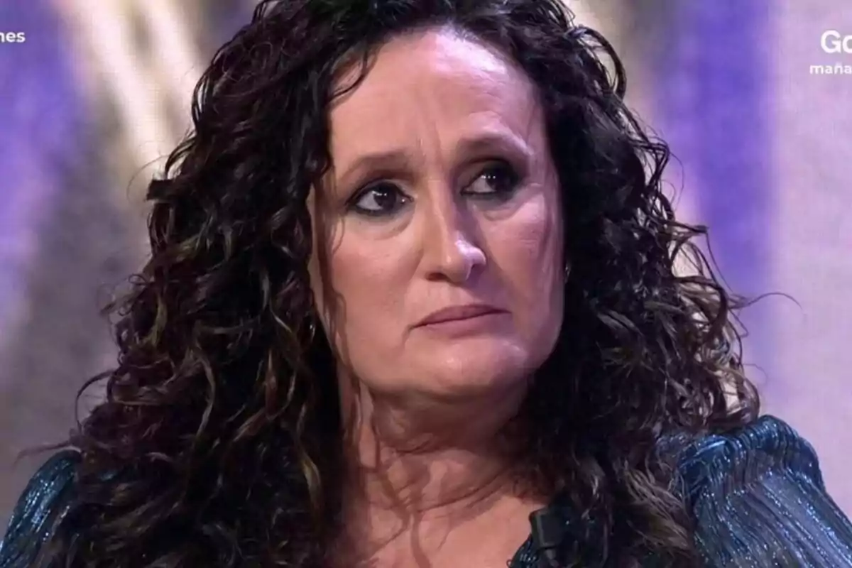 Dulce Delapiedra con cabello rizado y expresión seria en un entorno iluminado en el plató de De Viernes. Dulce Delapiedra con cabello rizado y expresión seria en un entorno iluminado en el plató de De Viernes.