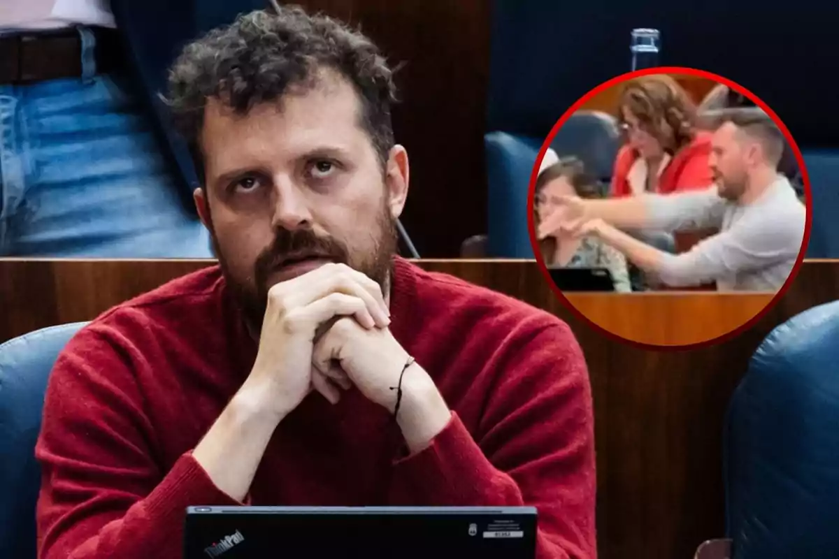 Un hombre con suéter rojo está sentado con las manos juntas frente a su rostro, mirando hacia arriba, con una computadora portátil en frente; en la esquina superior derecha de la imagen hay un círculo que muestra a otras personas gesticulando en una sala.