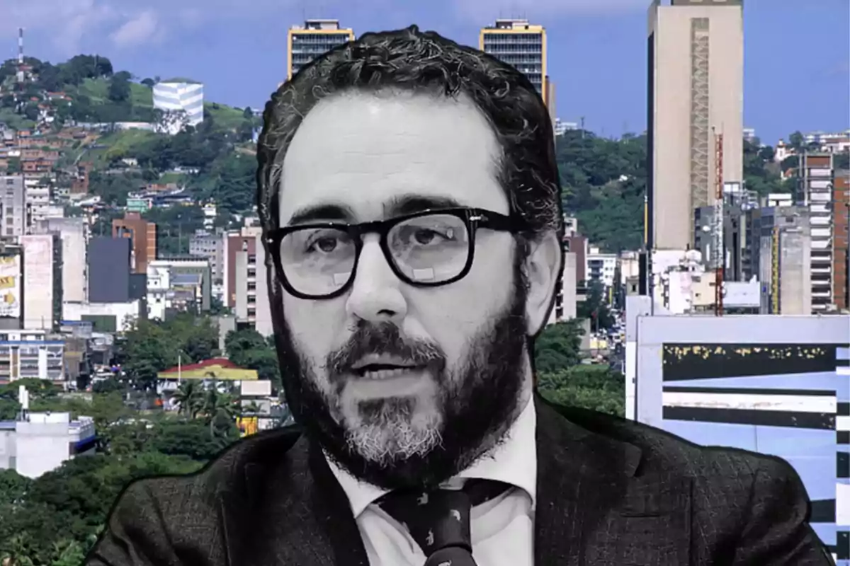 Un hombre con barba y gafas aparece en primer plano con una ciudad de fondo.