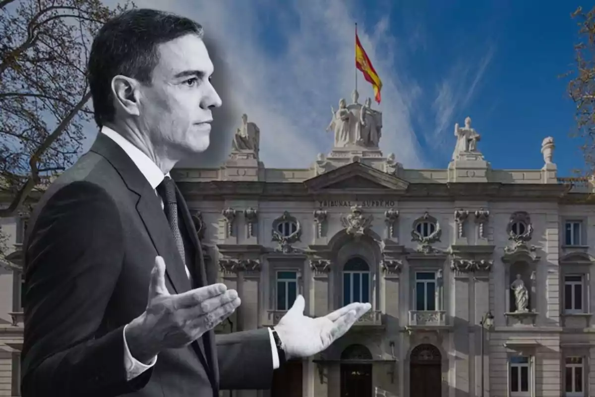 Un hombre en traje en blanco y negro con las manos extendidas frente a un edificio gubernamental con una bandera de España ondeando en la parte superior.