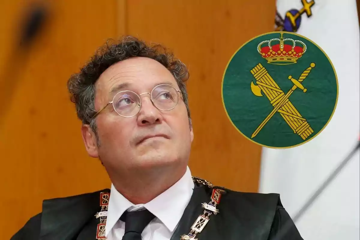 Un hombre con gafas y toga negra mira hacia arriba con un escudo verde y dorado en el fondo.