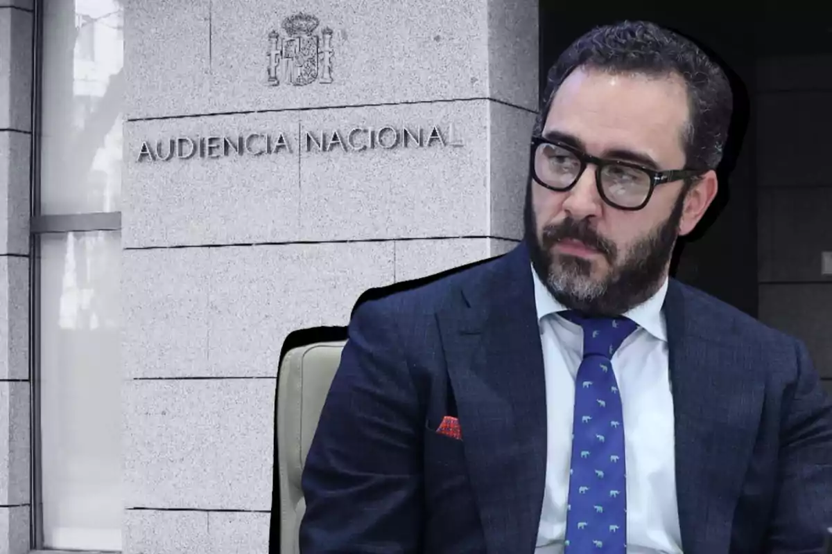 Un hombre con traje y corbata azul frente a un edificio con la inscripción Audiencia Nacional.