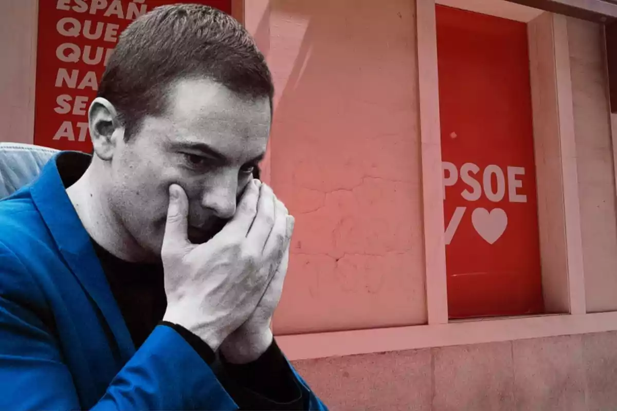 Un hombre con expresión pensativa y las manos en el rostro, frente a un cartel rojo con el logo del PSOE.