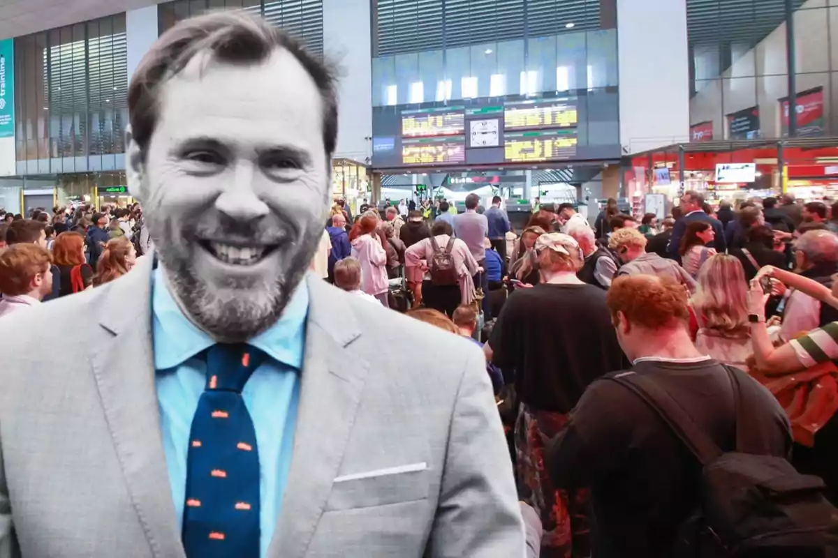 Un hombre sonriente con barba y traje claro está superpuesto sobre una imagen de una estación de tren llena de gente.