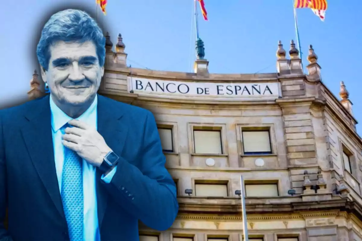 Hombre de traje sonriente frente a la fachada del Banco de España con banderas ondeando arriba