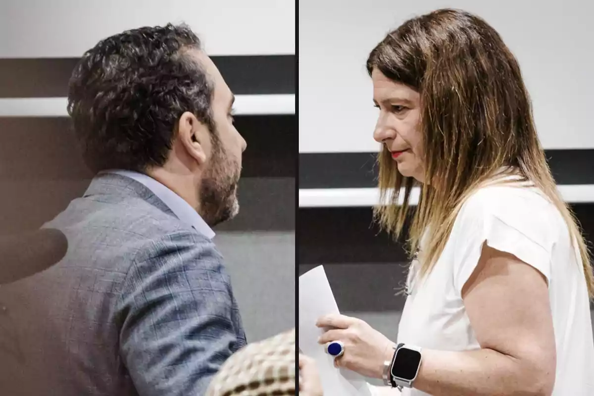 Un hombre y una mujer se miran de perfil en lo que parece ser una conversación seria en un entorno profesional