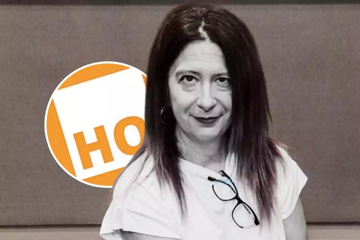 Mujer de cabello largo y lacio con gafas colgadas en la camiseta, posando frente a un fondo gris y un círculo con letras naranjas.