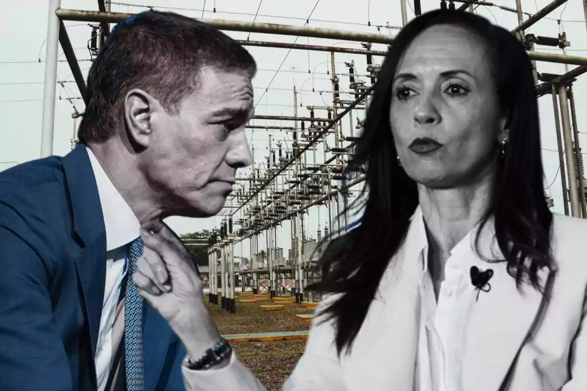 Dos personas vestidas de traje discuten frente a una subestación eléctrica