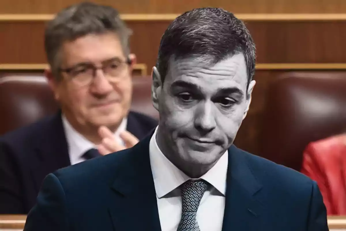 Hombre de traje con expresión seria en un entorno parlamentario