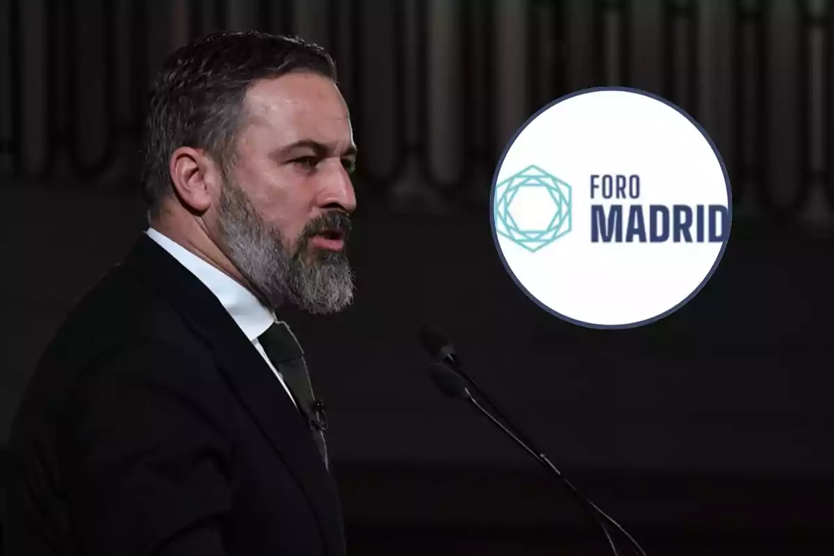 Hombre de barba y traje hablando frente a un micrófono con un logotipo de Foro Madrid al fondo