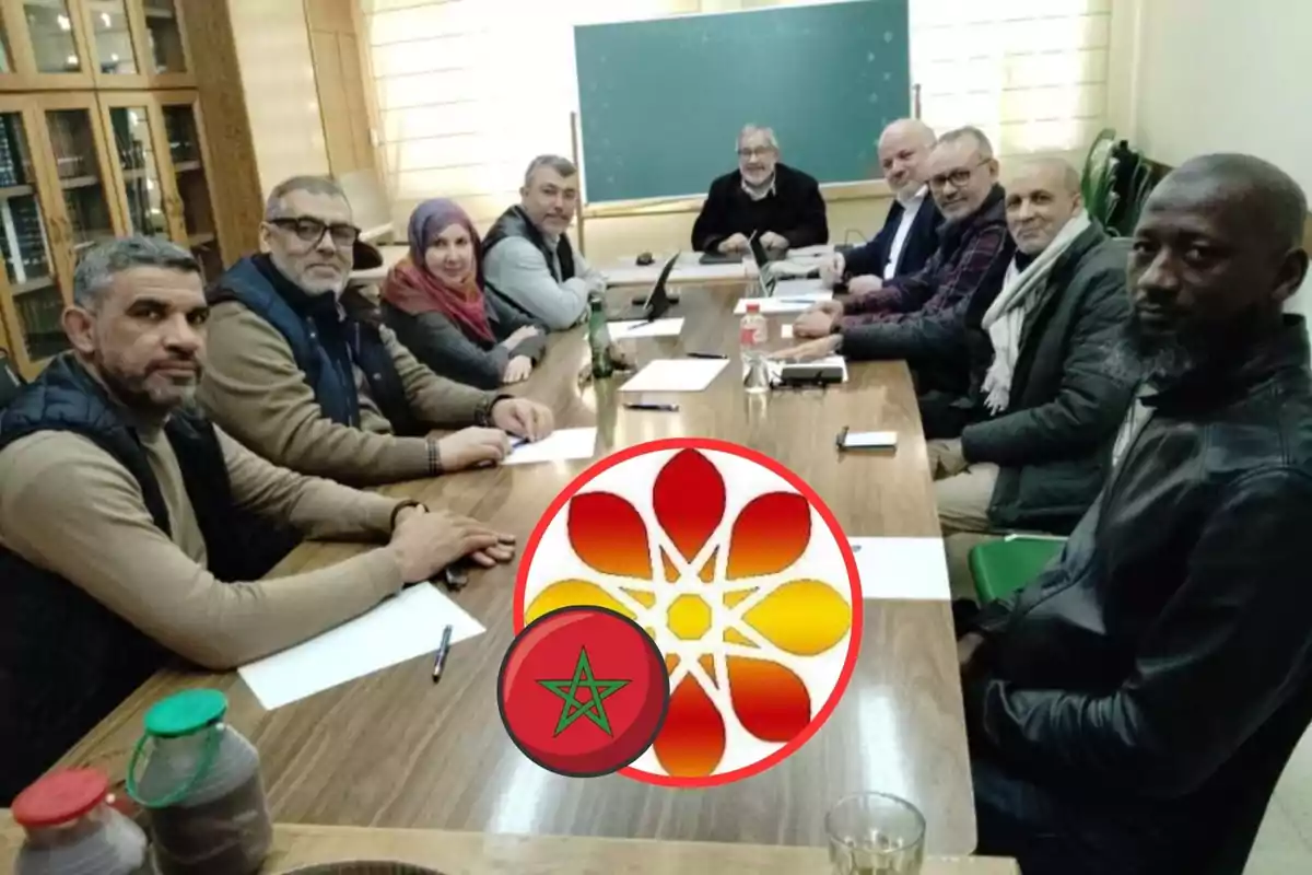 Un grupo de personas sentadas alrededor de una mesa en una sala de reuniones con una pizarra al fondo y un logotipo superpuesto en la imagen.