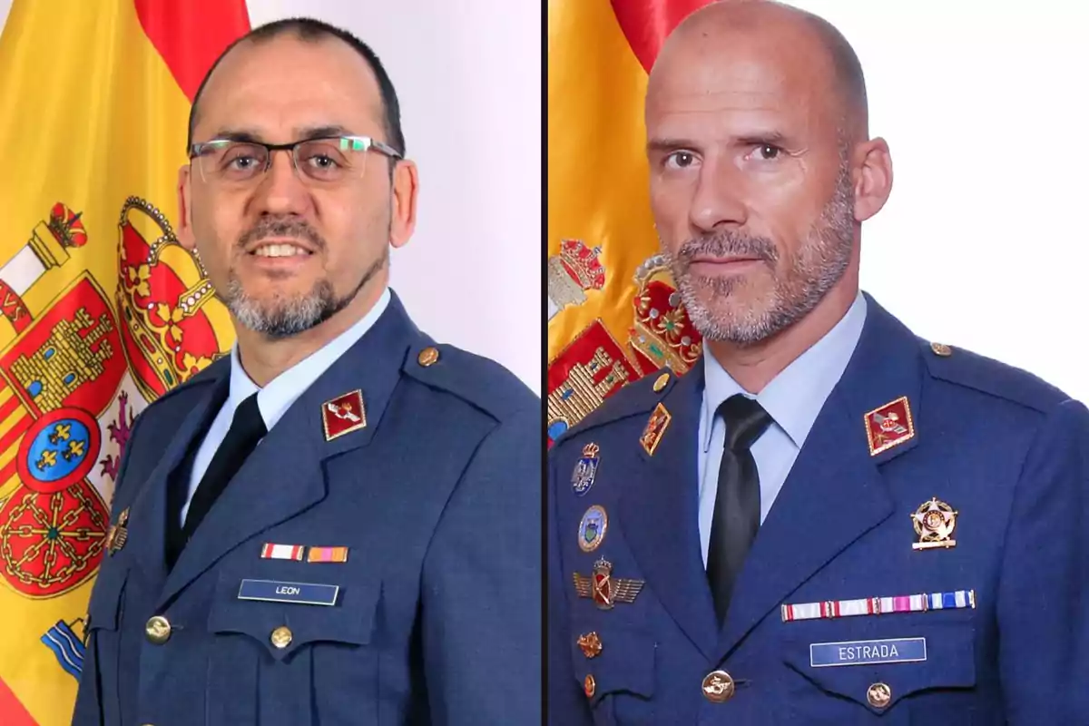 Dos hombres en uniforme militar posan frente a una bandera española.