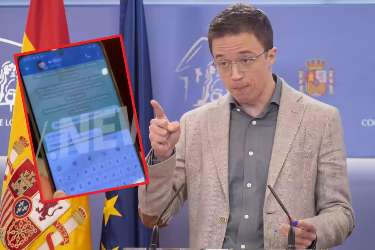 Un hombre con gafas y chaqueta clara gesticula mientras habla en una conferencia de prensa con banderas de España y la Unión Europea detrás de él y un recuadro muestra un teléfono móvil con una conversación de chat en la pantalla.