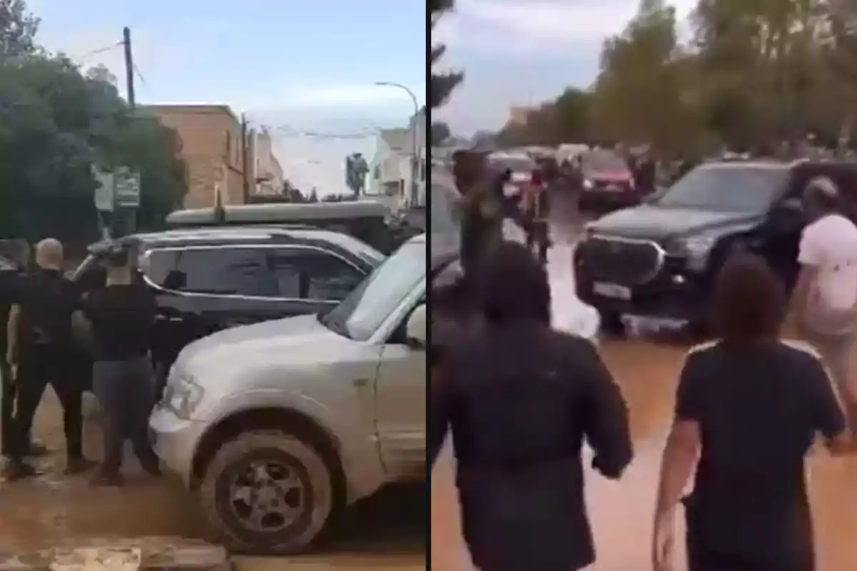 Personas y vehículos en una calle, con un grupo de personas observando y algunos autos en movimiento.