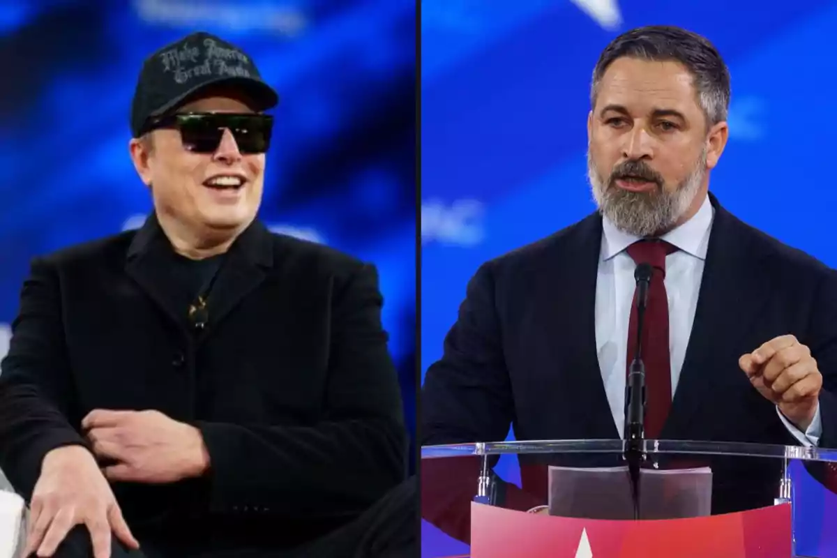 Two men on a stage with a blue background, one wearing sunglasses and a cap, the other speaking at a podium.