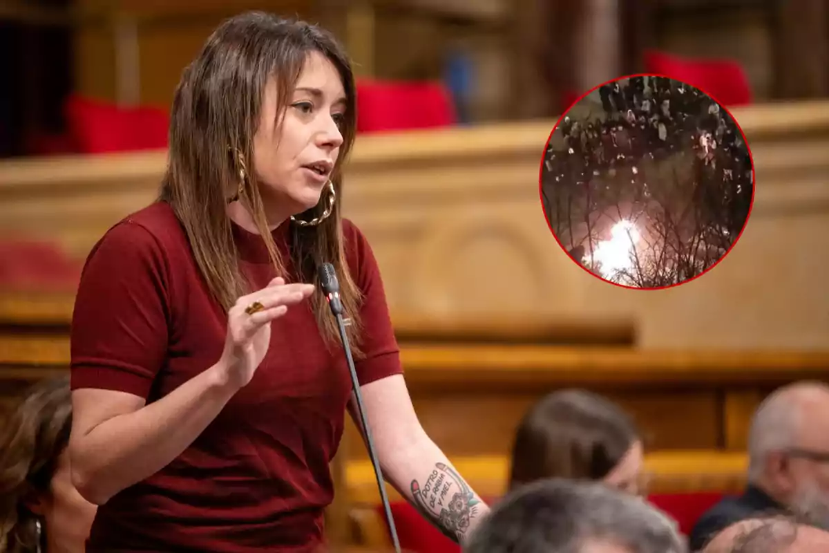 Una mujer hablando en un podio con un micrófono, lleva una camiseta roja y tiene un tatuaje en el brazo, en la esquina superior derecha hay un círculo que muestra una escena de una multitud y un fuego.