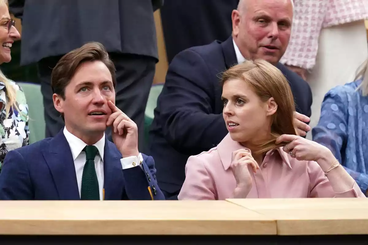 Edoardo Mapelli and Beatrice of York seated at a sporting event, surrounded by other people, with expressions of interest and conversation. Edoardo Mapelli and Beatrice of York seated at a sporting event, surrounded by other people, with expressions of interest and conversation.