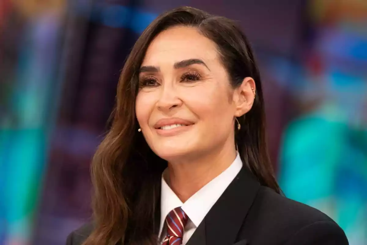 Vicky Martín Berrocal sonriendo mientras lleva un traje formal con corbata en un fondo colorido y desenfocado. Captura de 'El Hormiguero' Vicky Martín Berrocal sonriendo mientras lleva un traje formal con corbata en un fondo colorido y desenfocado. Captura de 'El Hormiguero'
