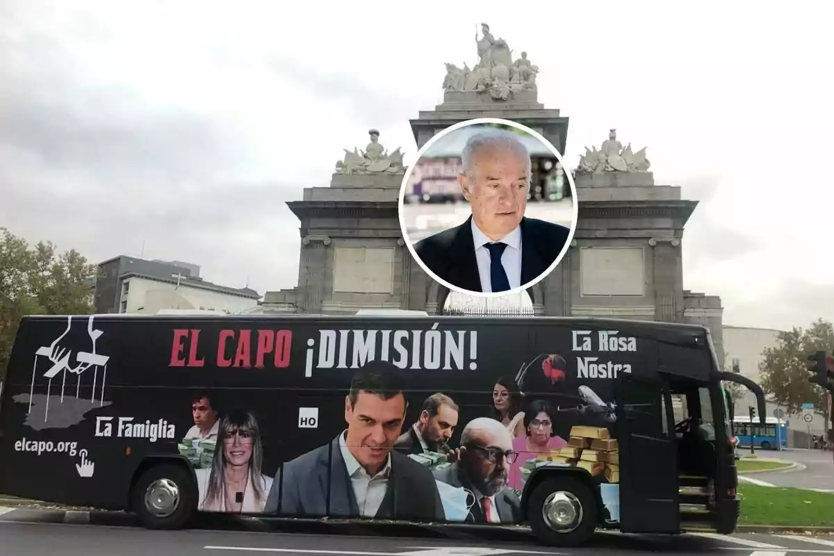 Un autobús con imágenes y mensajes políticos está estacionado frente a un monumento, con un retrato de un hombre en un círculo sobre el monumento.