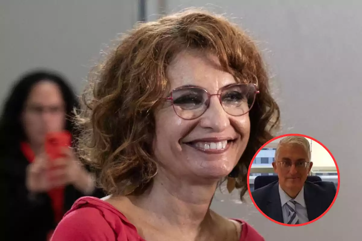 A smiling woman with glasses and curly hair, with a frame showing a man with glasses and a suit.