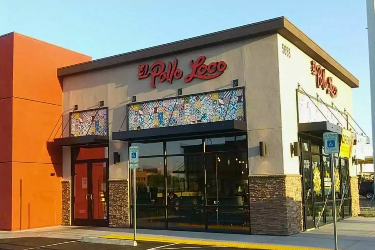 Facade of an El Pollo Loco restaurant with beige walls and orange accents, large windows, and a red sign on the top. Facade of an El Pollo Loco restaurant with beige walls and orange accents, large windows, and a red sign on the top.