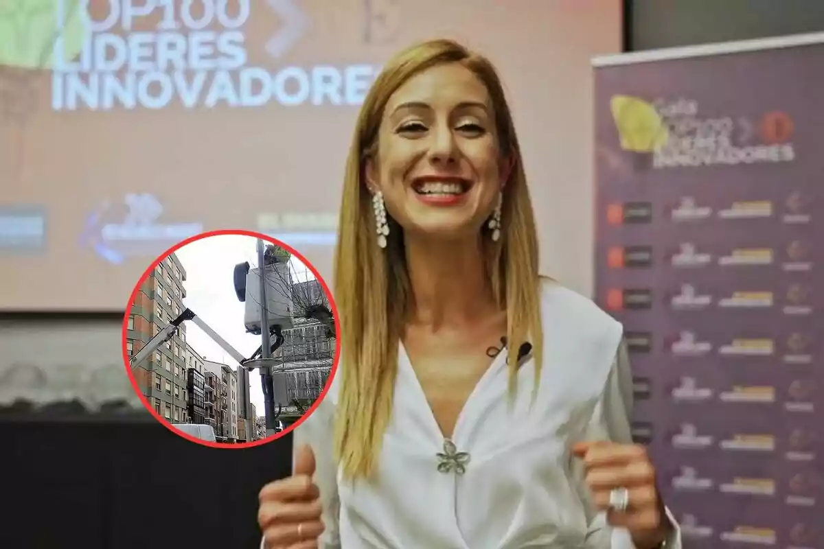 Una persona sonriente en un evento con un fondo que dice "Top 100 Líderes Innovadores" y un recuadro que muestra una escena urbana con un poste y edificios.