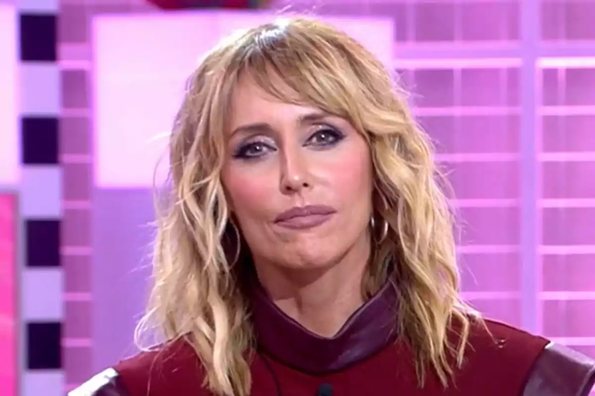 Primer plano de Emma García con expresión seria en Fiesta con un fondo colorido. Primer plano de Emma García con expresión seria en Fiesta con un fondo colorido.