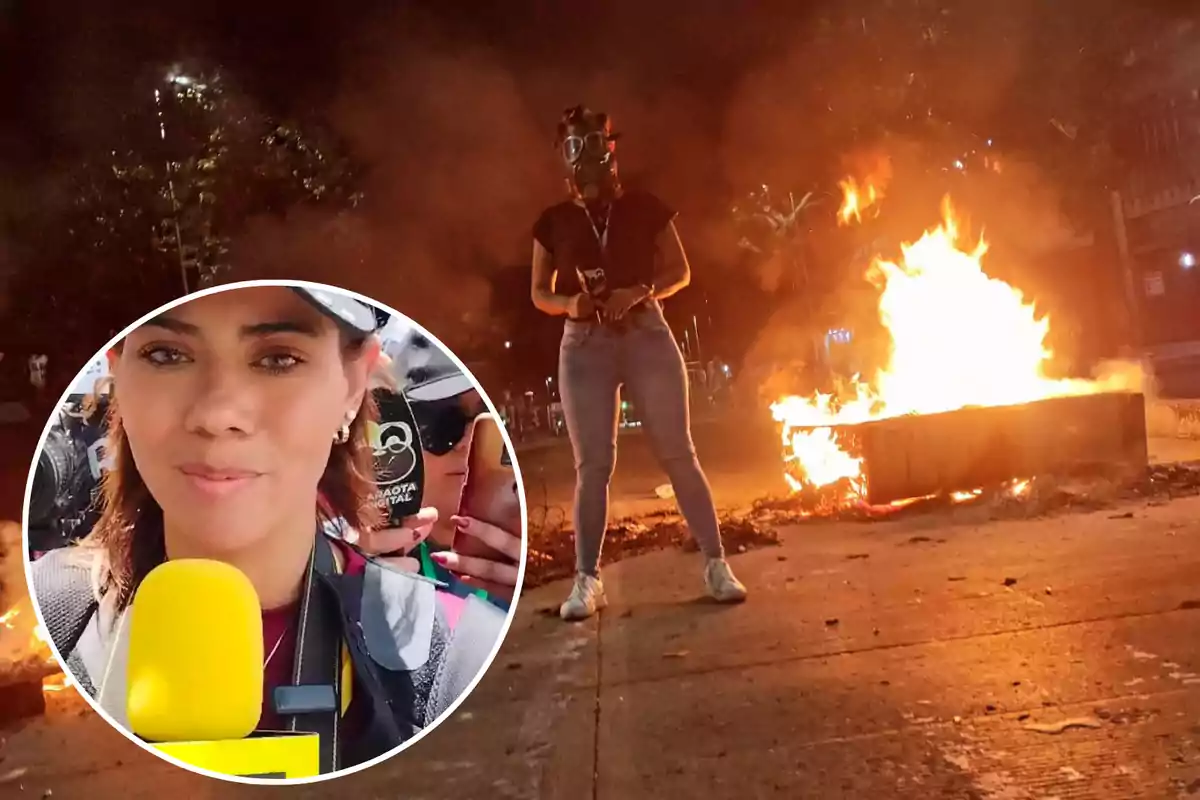 Una reportera con micrófono amarillo y gafas de protección cubre una protesta nocturna con fuego en la calle.