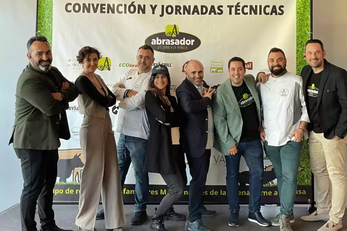 Un grupo de personas posando frente a un cartel que dice "Convención y Jornadas Técnicas Abrasador".