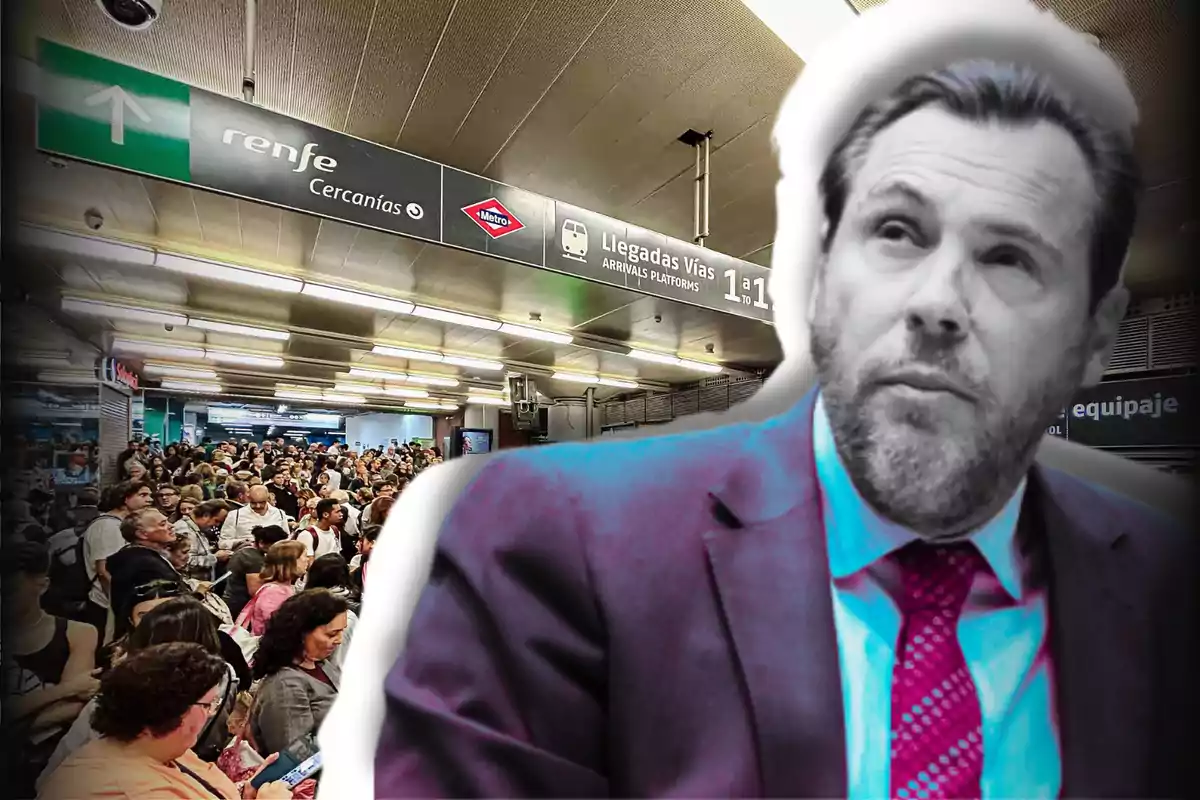 Una multitud de personas espera en una estación de tren con un cartel de Renfe Cercanías y Metro, mientras un hombre con traje y corbata aparece en primer plano.