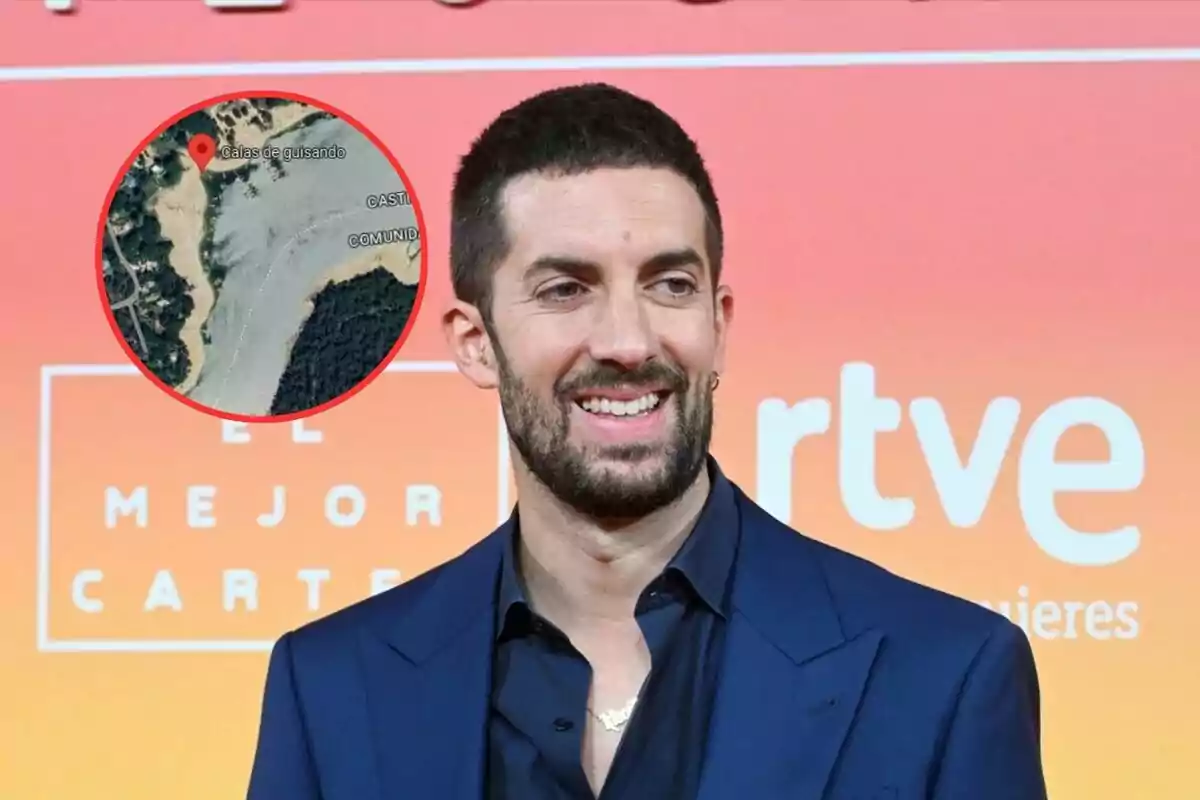 Un hombre con barba y cabello corto sonríe en un evento con un fondo de colores cálidos y un logotipo de RTVE.