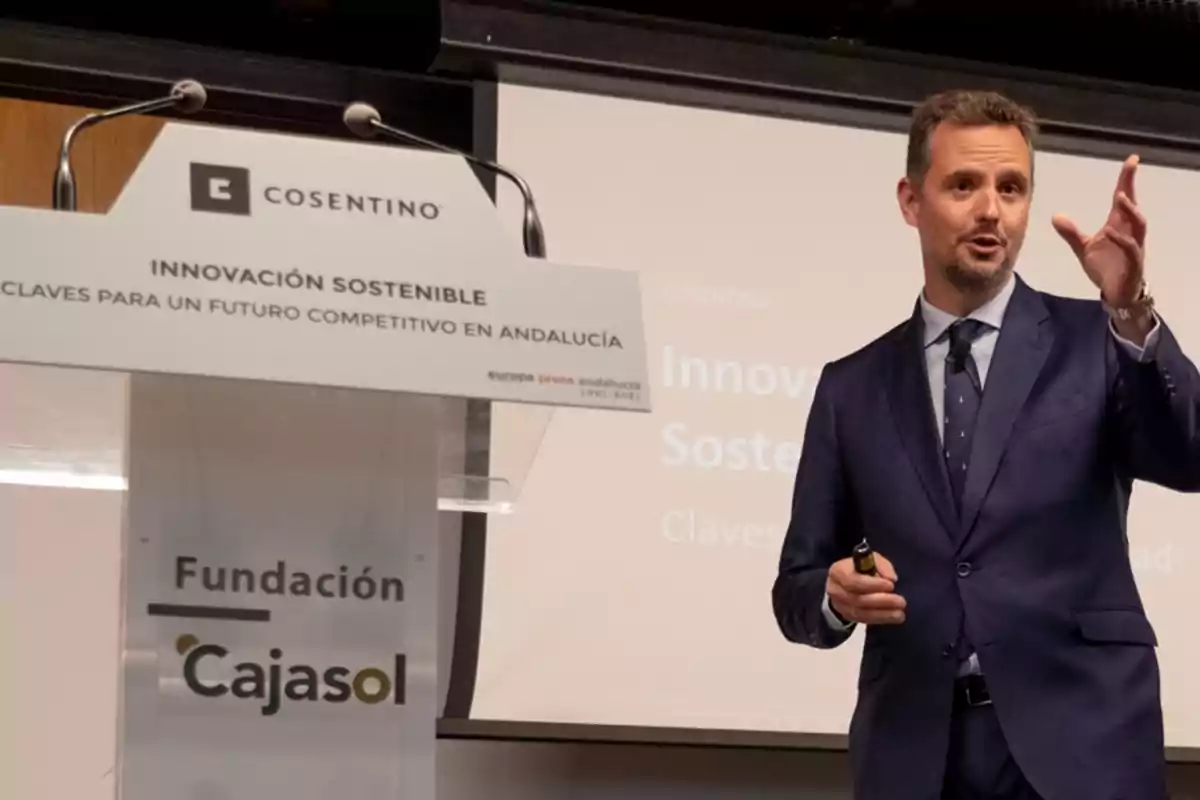 Un hombre en traje azul hablando en un podio durante un evento sobre innovación sostenible en Andalucía, organizado por la Fundación Cajasol y Cosentino.