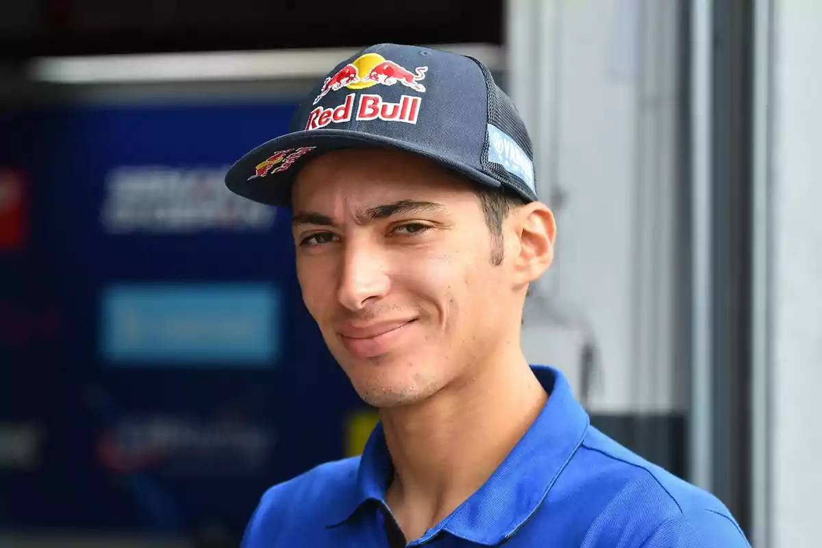 Un hombre con una gorra de Red Bull y una camiseta azul sonríe a la cámara.