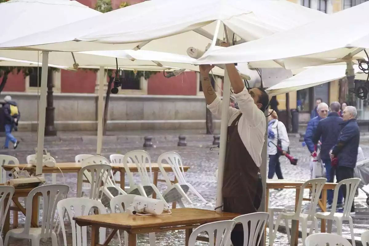 Un camarero coloca una sombrilla en Sevilla