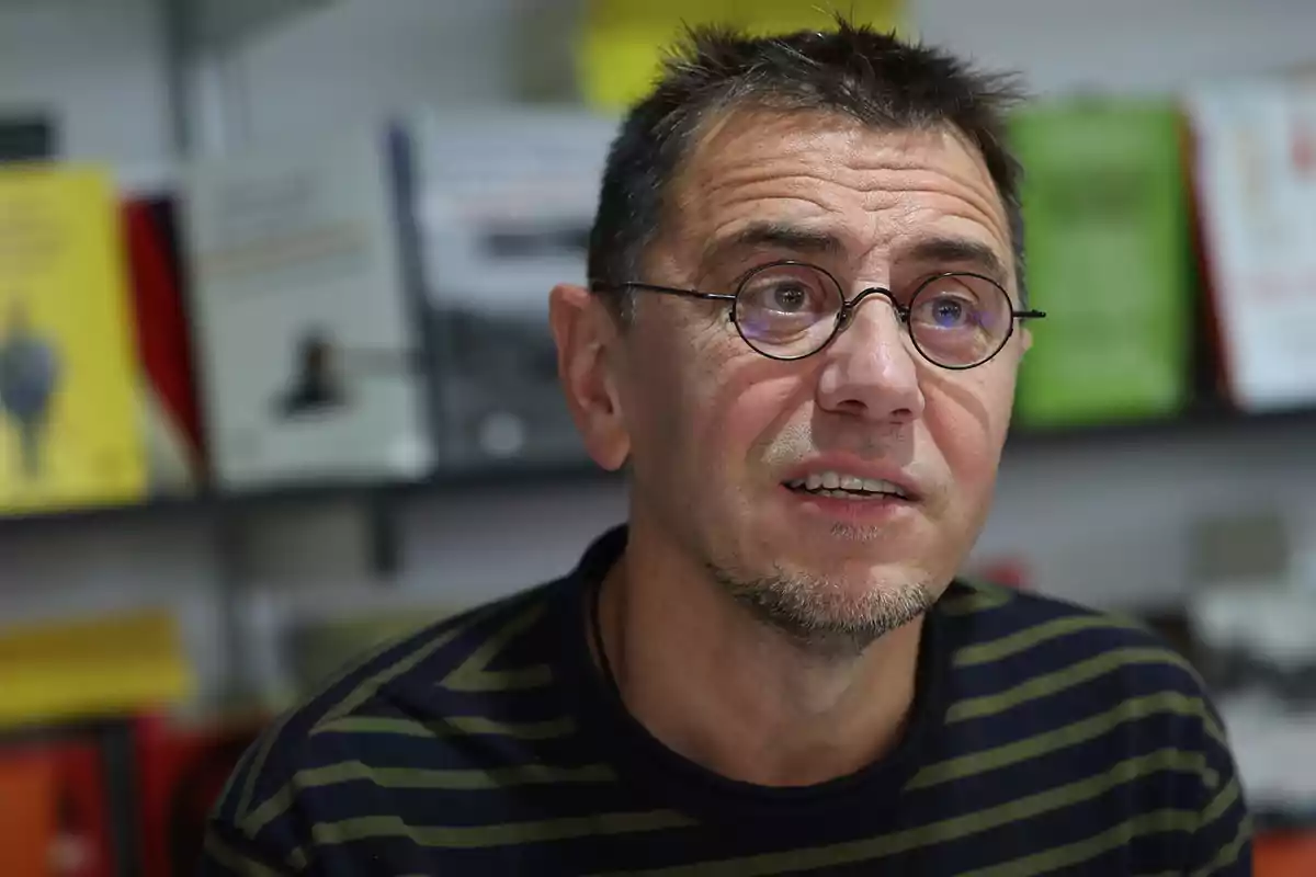 A man with glasses and a striped T-jersey in a bookstore.