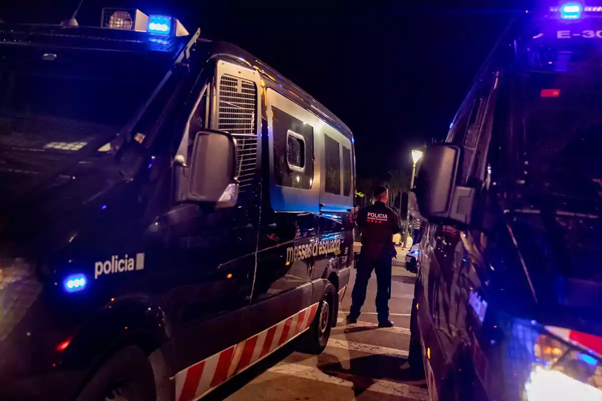 Furgones de policía con luces encendidas en una operación nocturna.