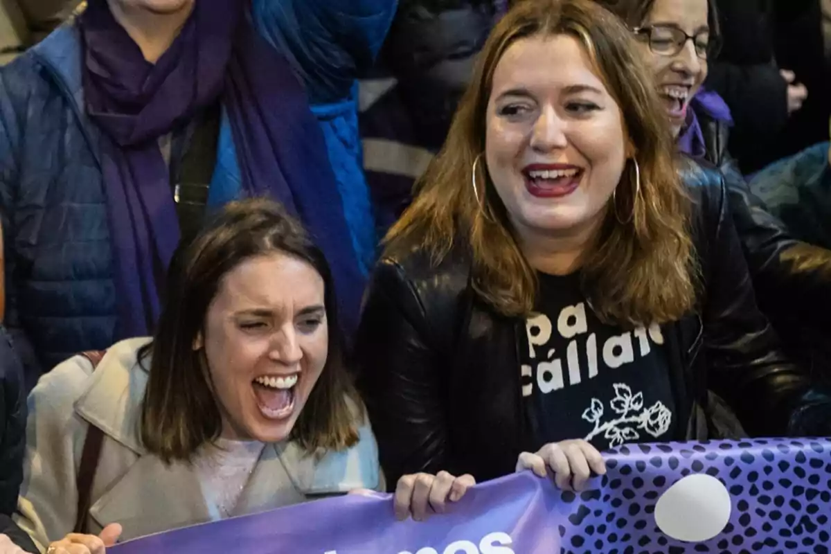 Personas sonriendo y sosteniendo una pancarta en un evento.