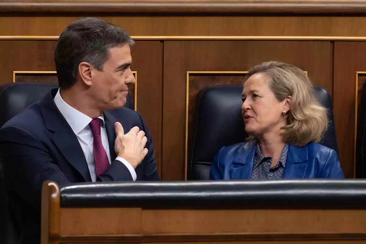 Dos personas conversando en un entorno formal.