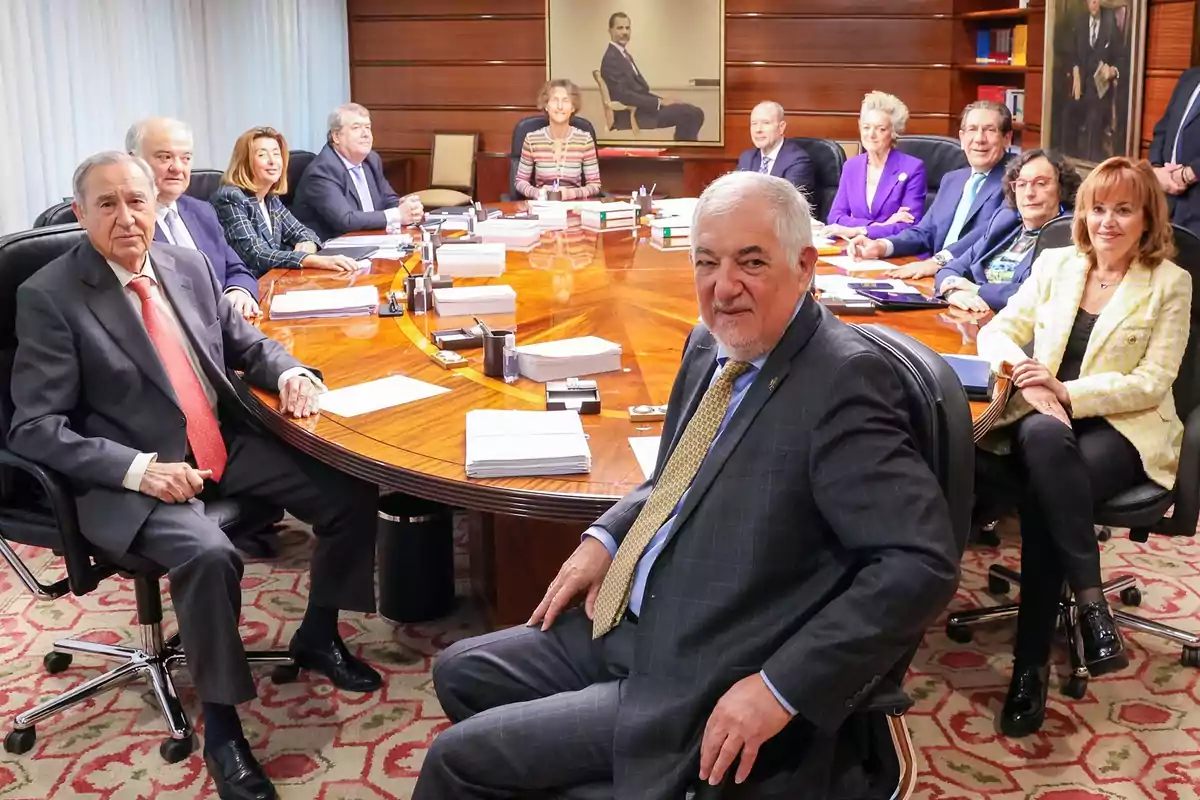 Un grupo de personas sentadas alrededor de una mesa de conferencias en una sala de reuniones.