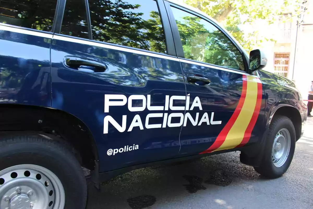 Coche de la Policía Nacional con diseño de bandera en el lateral.