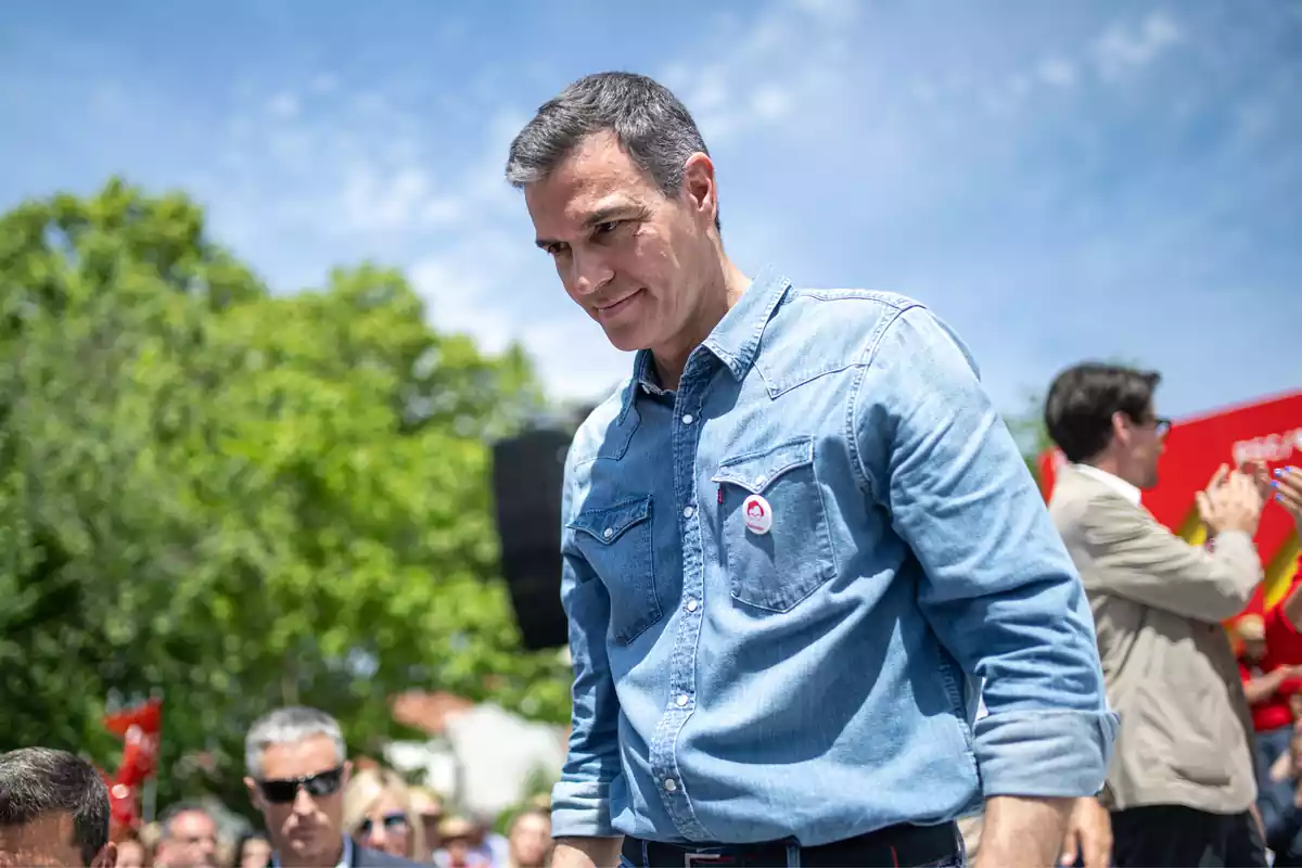 Pedro Sánchez en un acto político, mirando hacia abajo