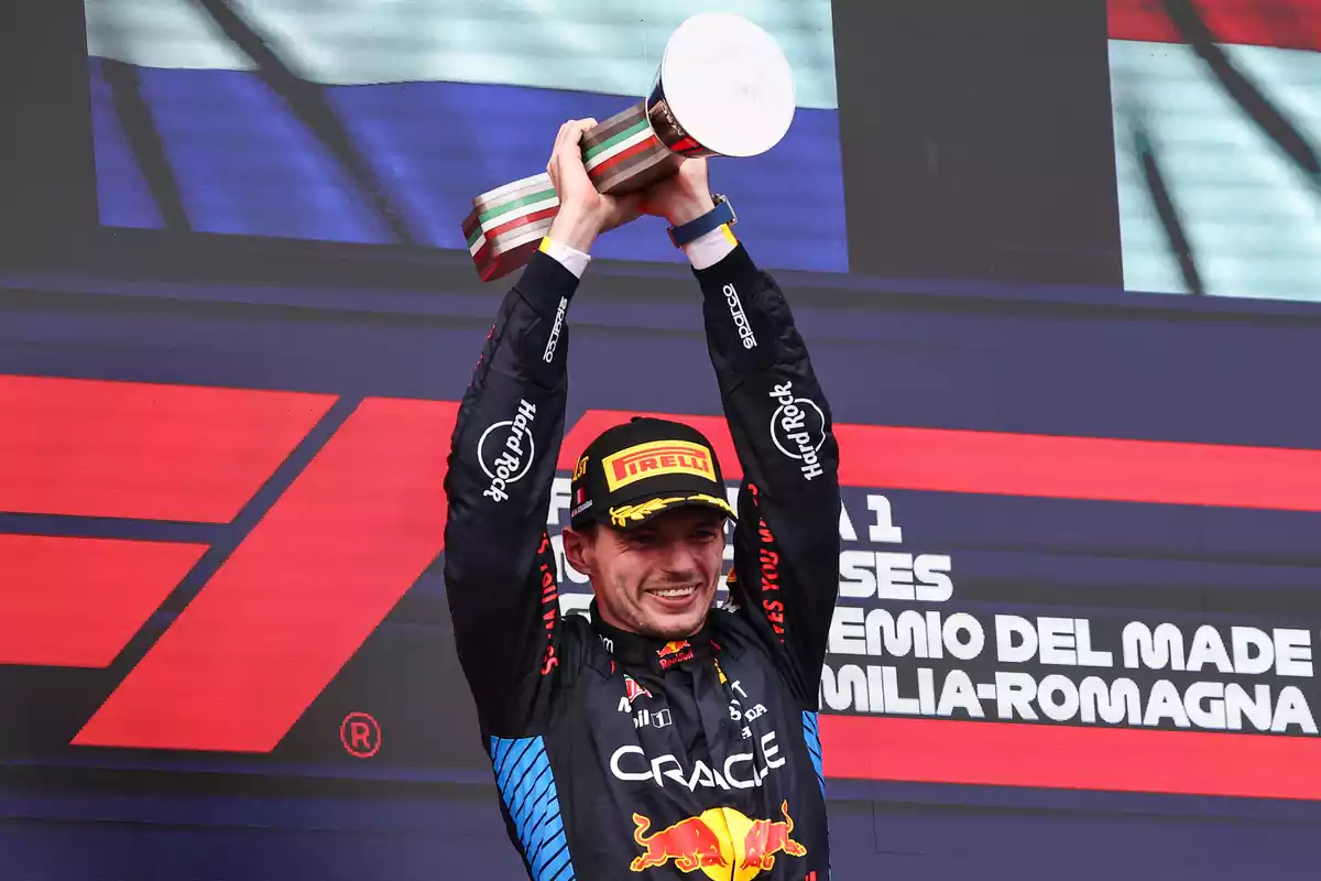Max Verstappen recogiendo su premio en el podio del circuito de Imola levantando su trofeo