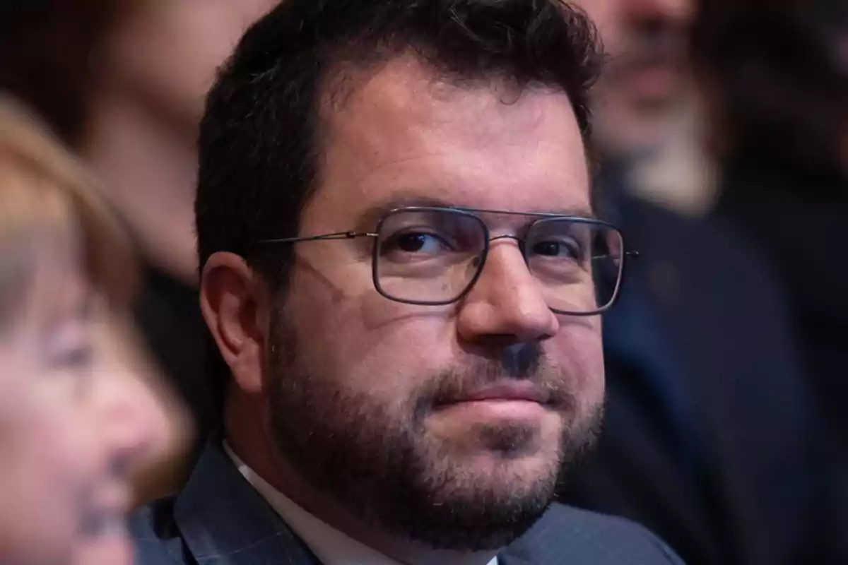 Hombre con barba y gafas en un evento.