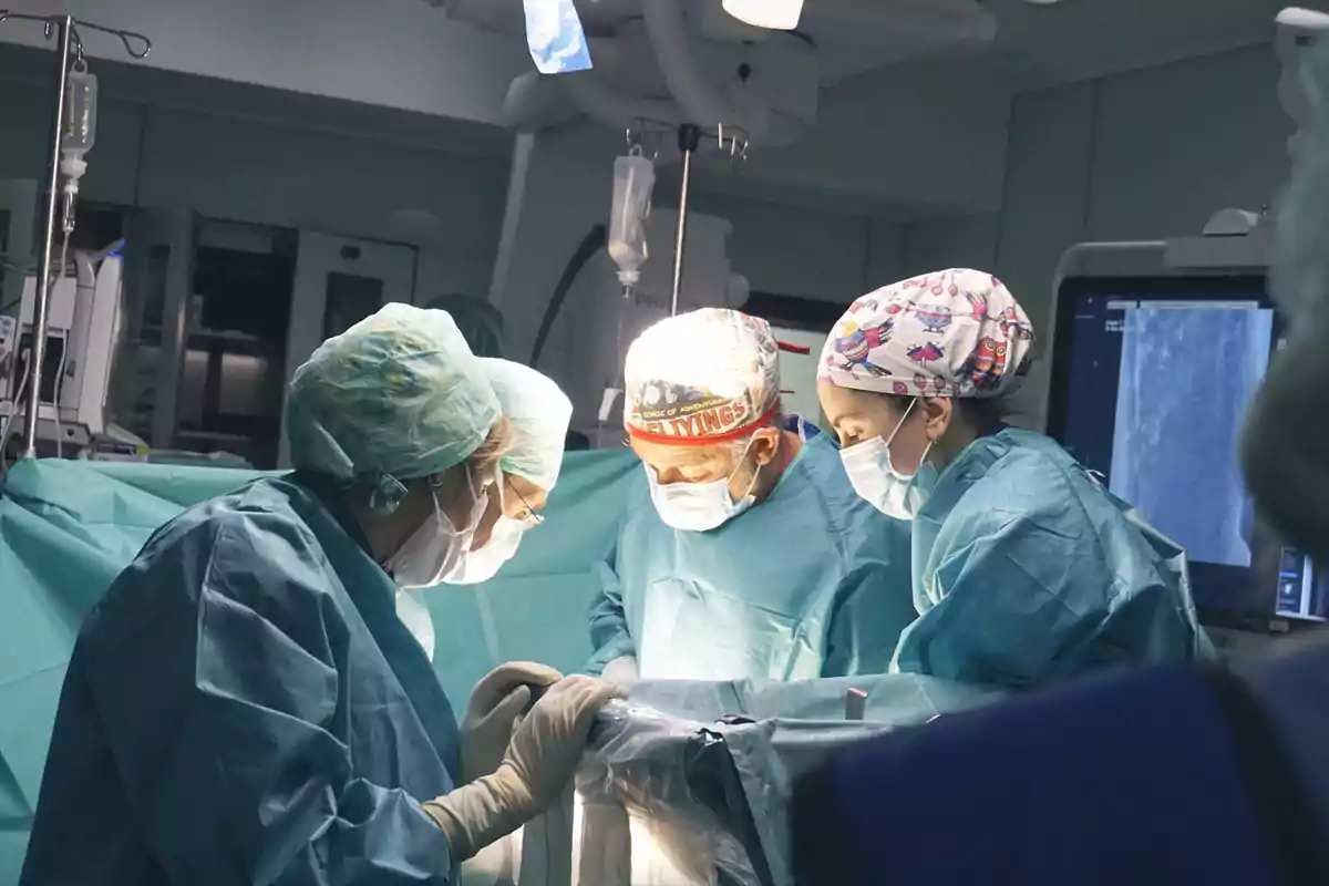 A team of surgeons performs an operation in an operating room.