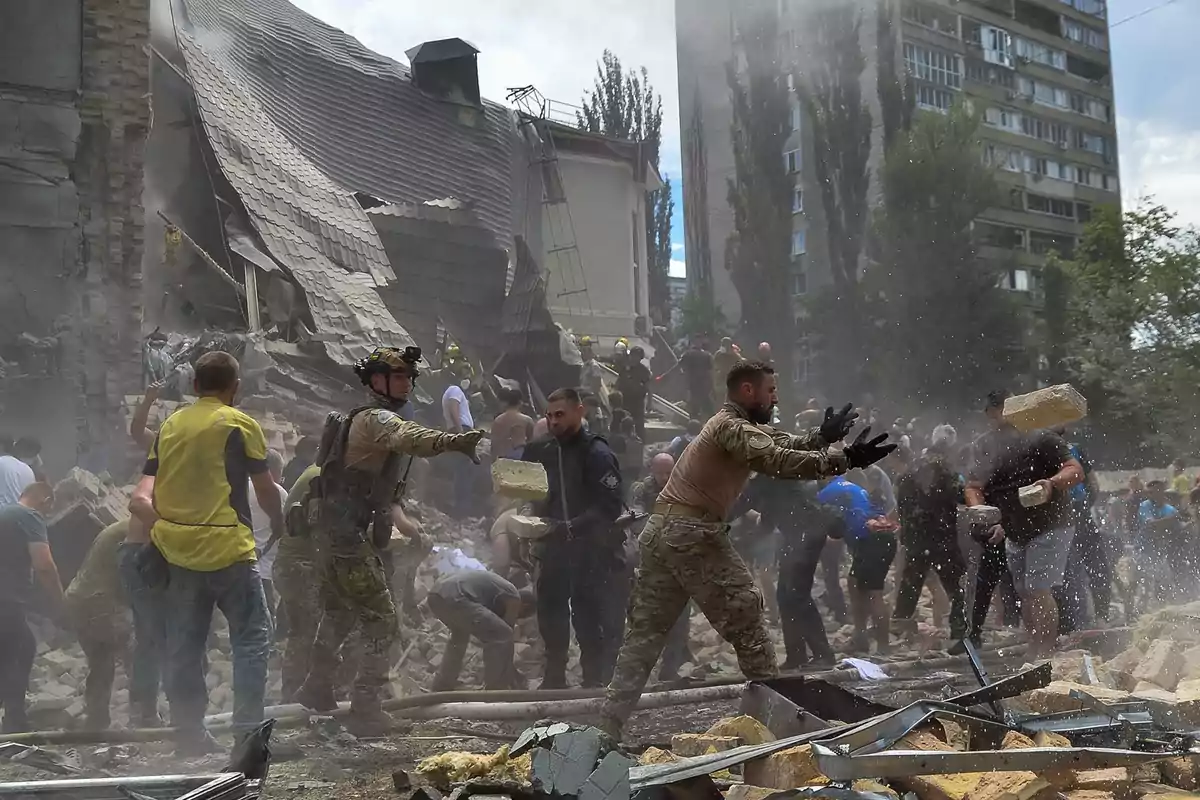 Personas trabajando en la remoción de escombros tras el colapso de un edificio.