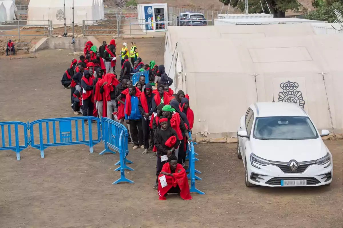 Several migrants wait to be transferred to the port of La Estaca