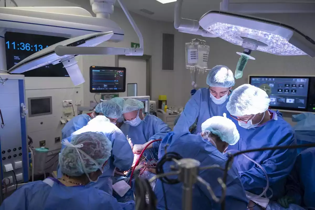 Equipo médico realizando una cirugía en un quirófano iluminado.